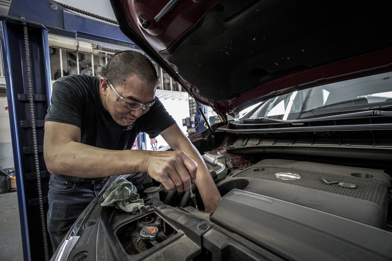 auto repairman checking the engine under the hood of the car