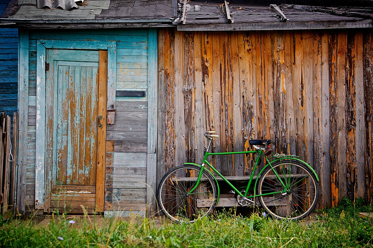 a bicycle parked next to an old wooden shack