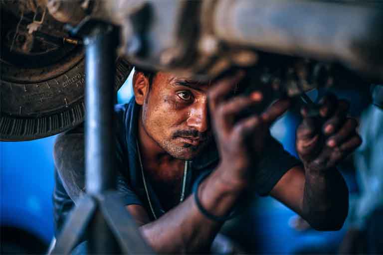 an auto mechanic fixing the engine found in the underbody of the car