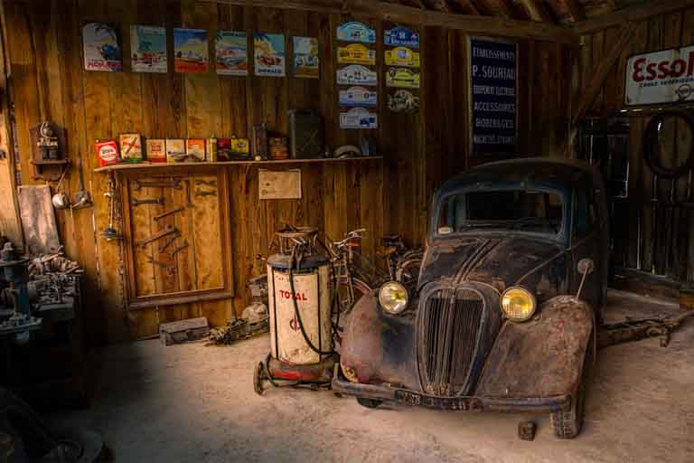 inside the wooden garage with old and rusty vintage car