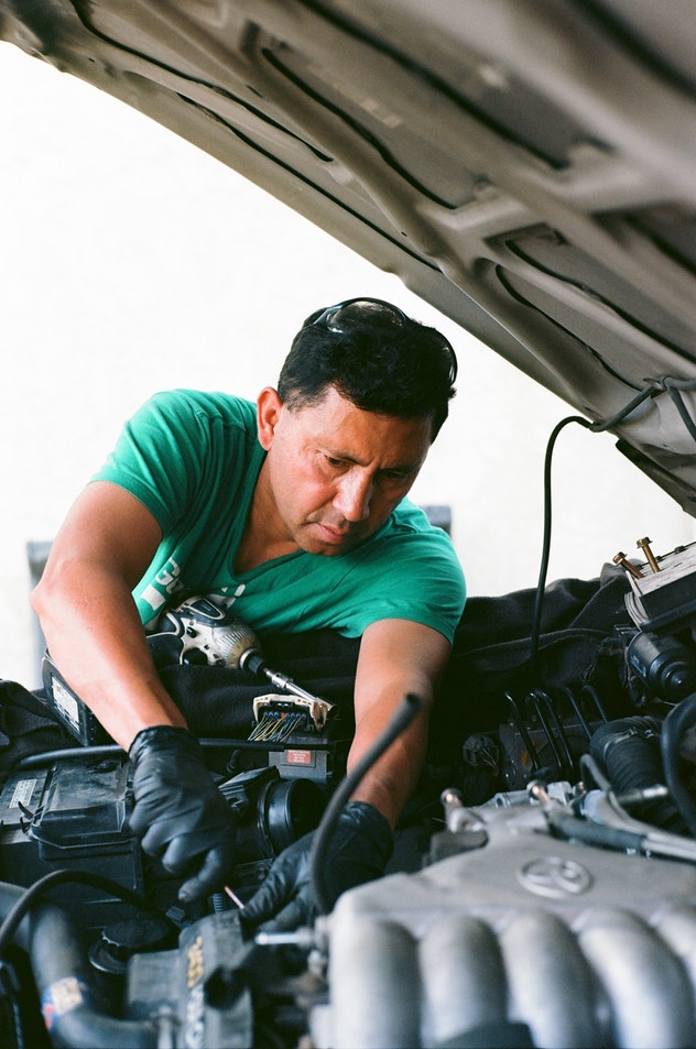a local auto mechanic working under the hood of the car